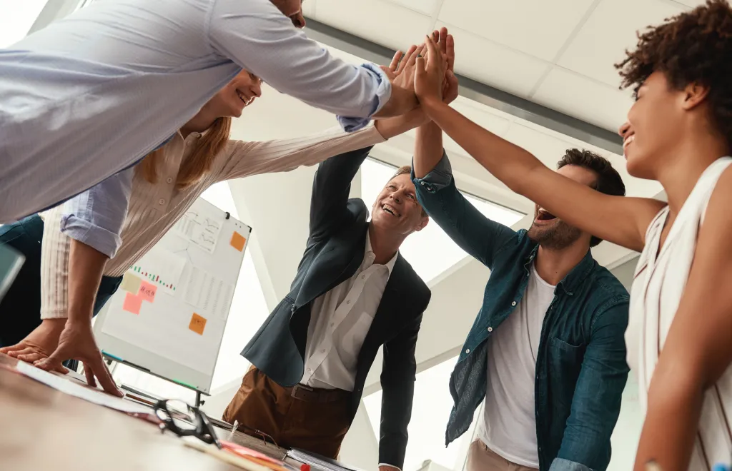 5 people celebrating their team achievement - team cohesion
